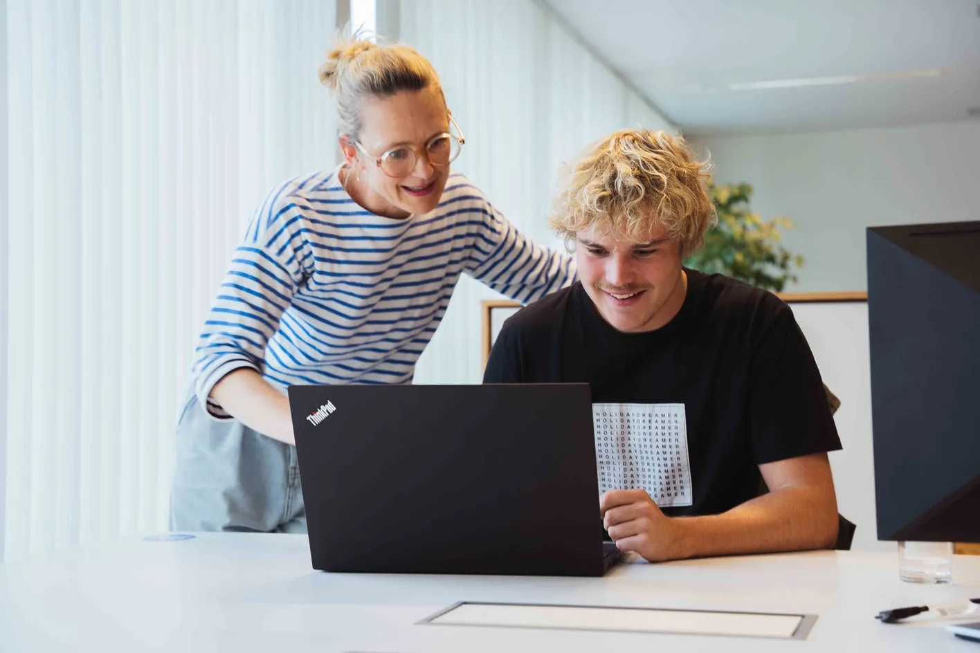 Anchr collega's kijken samen op een laptopscherm